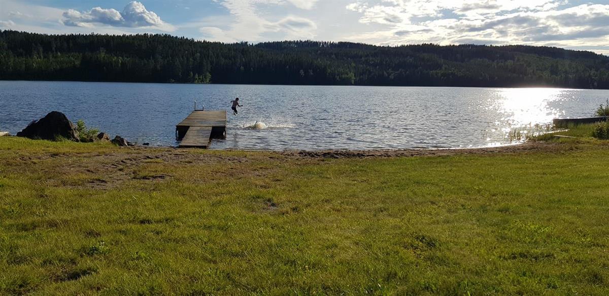 Barn hopper fra brygge og bader i sjøen - Klikk for stort bilde
